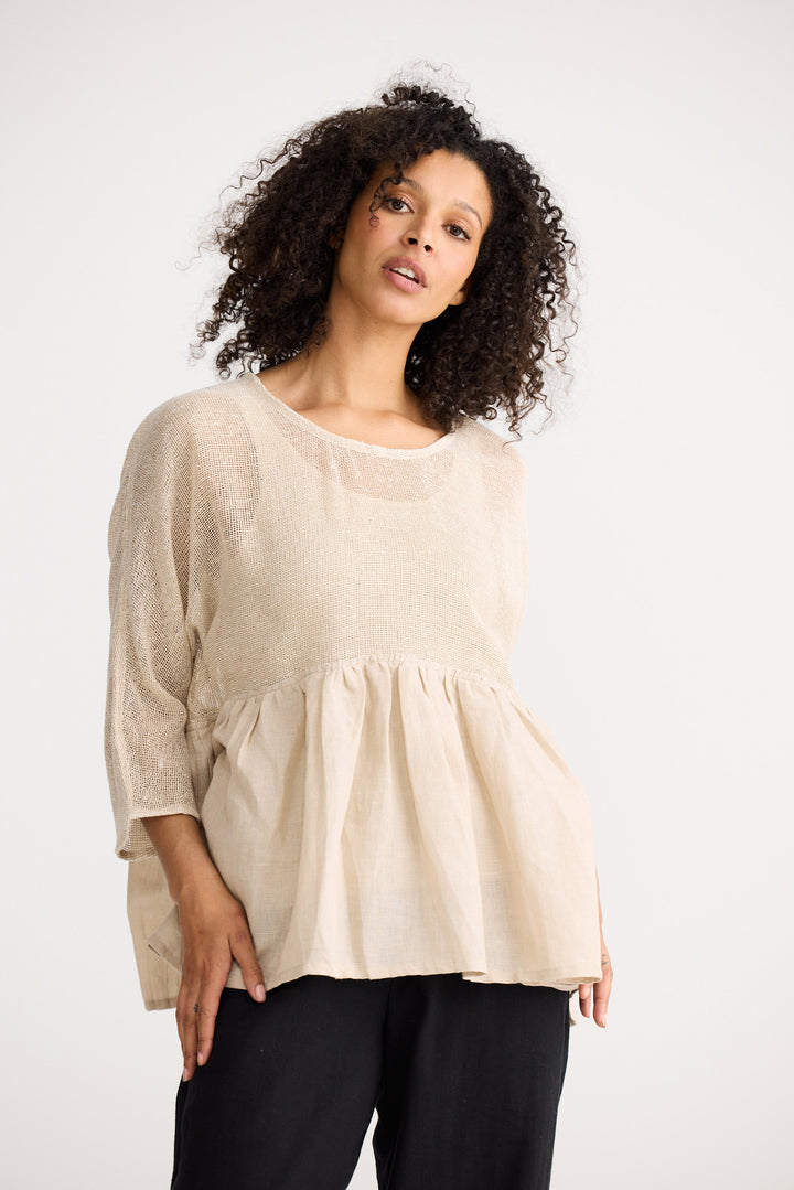 Model wearing natural Nikita Top, side view on white background