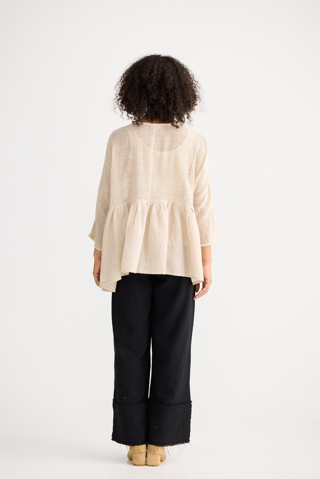 Model wearing natural Nikita Top, back view on white background