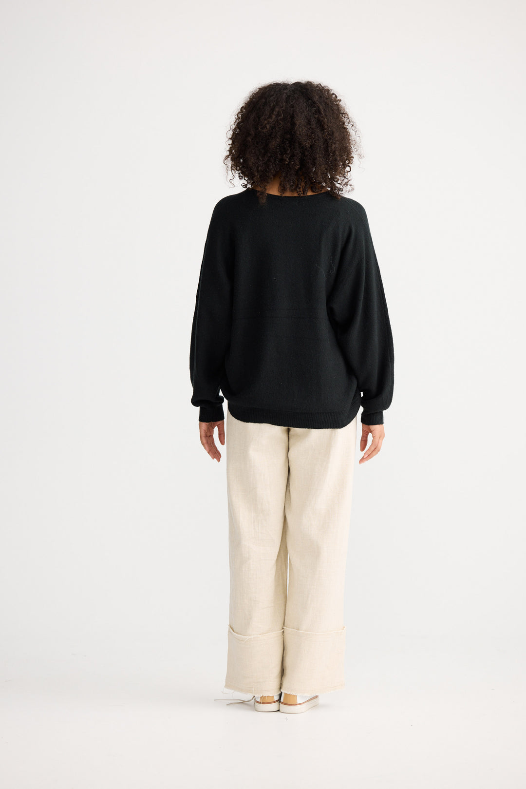 Model wearing charcoal Freddie Knit, side view on white background