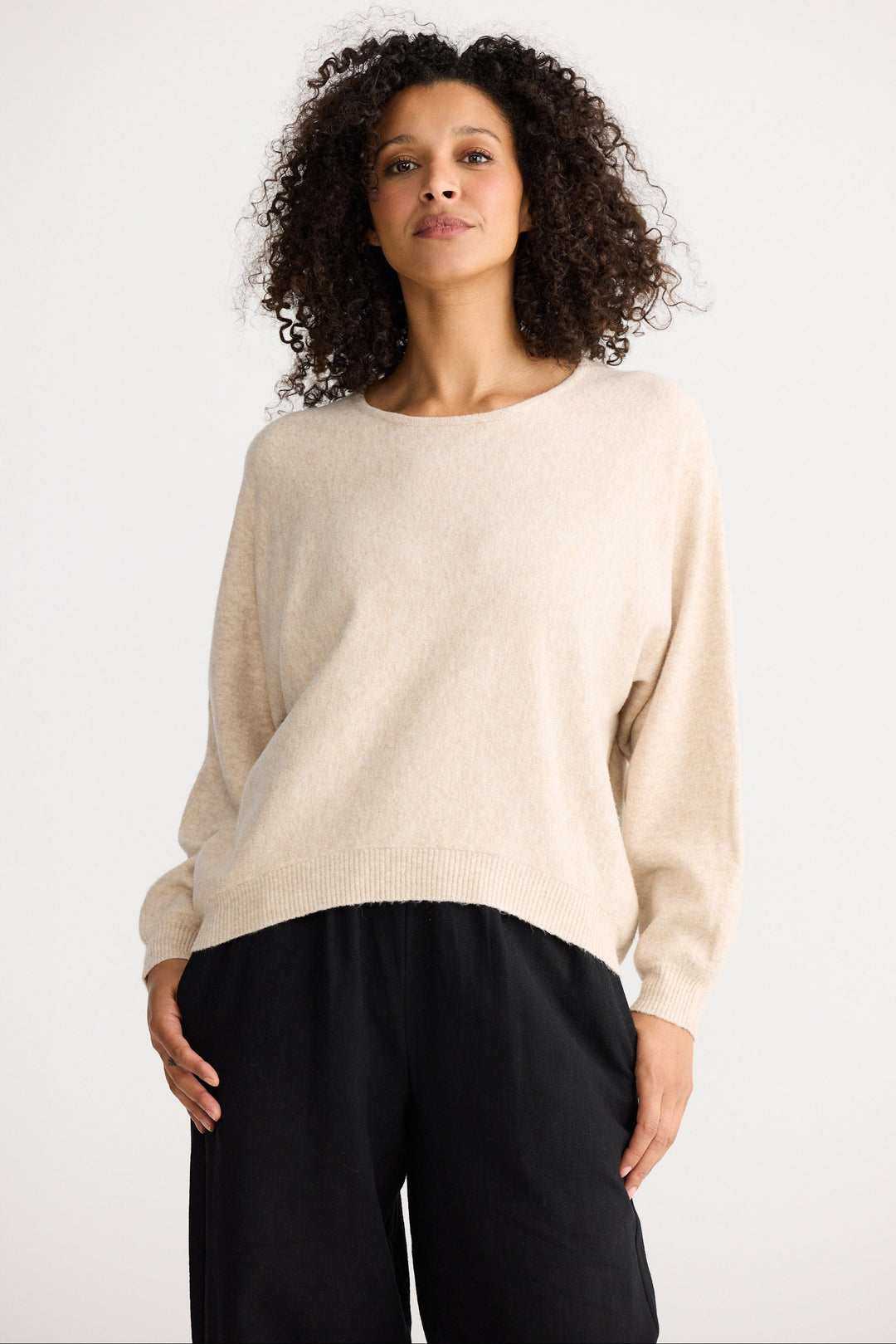 Model wearing oatmeal Freddie Knit, back view on white background