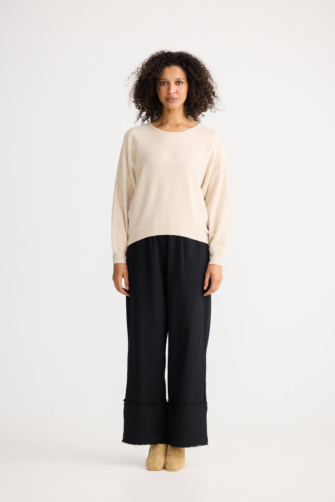 Model wearing oatmeal Freddie Knit, side view on white background