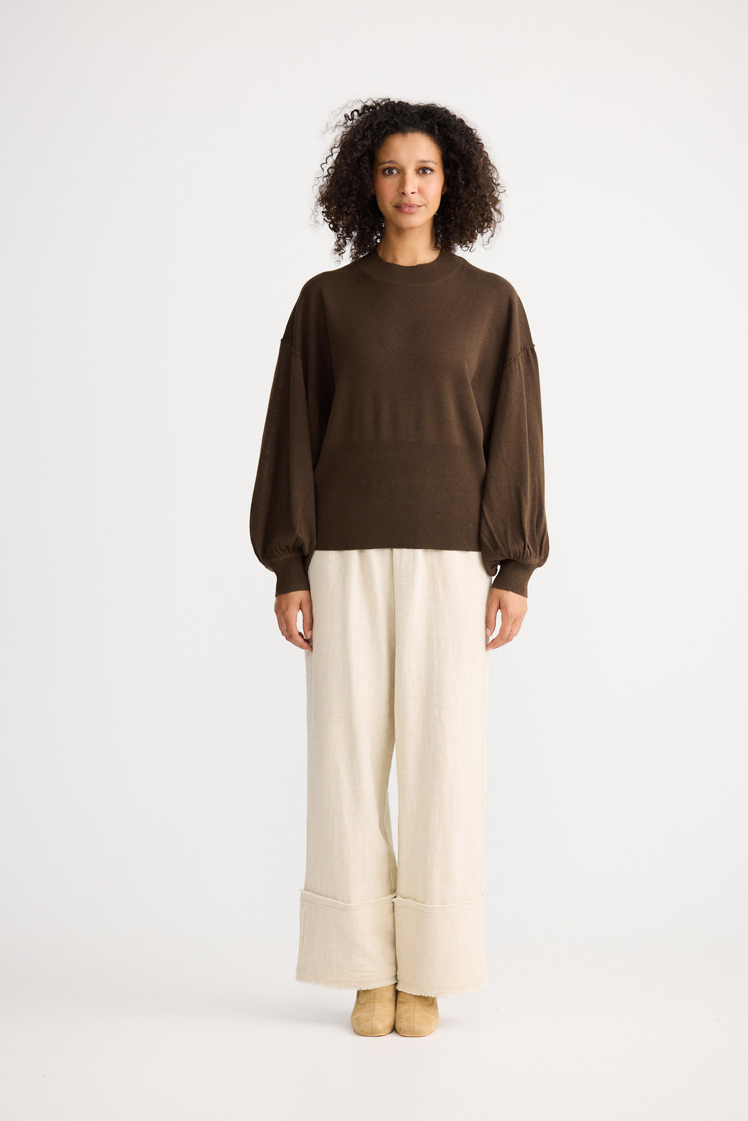 Model wearing chocolate Anais Knit Top, back view on white background