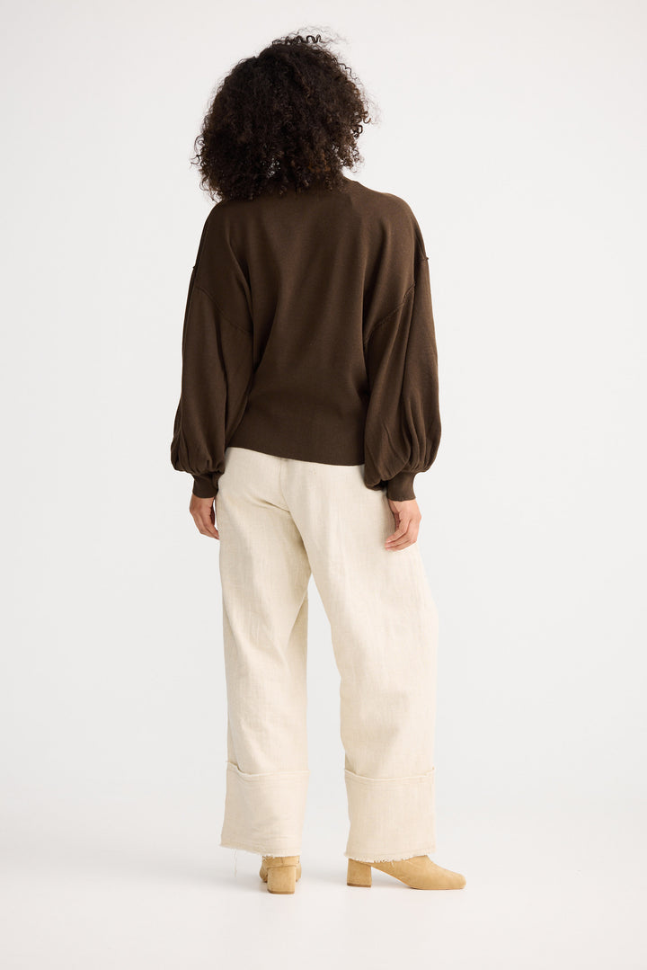 Model wearing chocolate Anais Knit Top, side view on white background