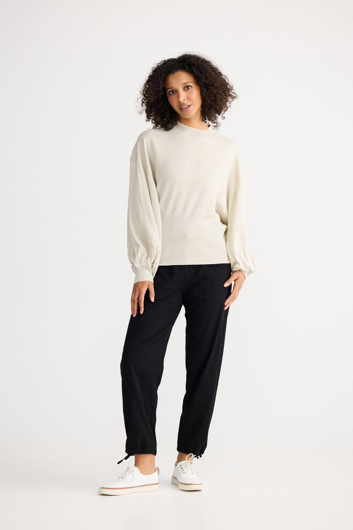 Model wearing oatmeal Anais Knit Top, side view on white background