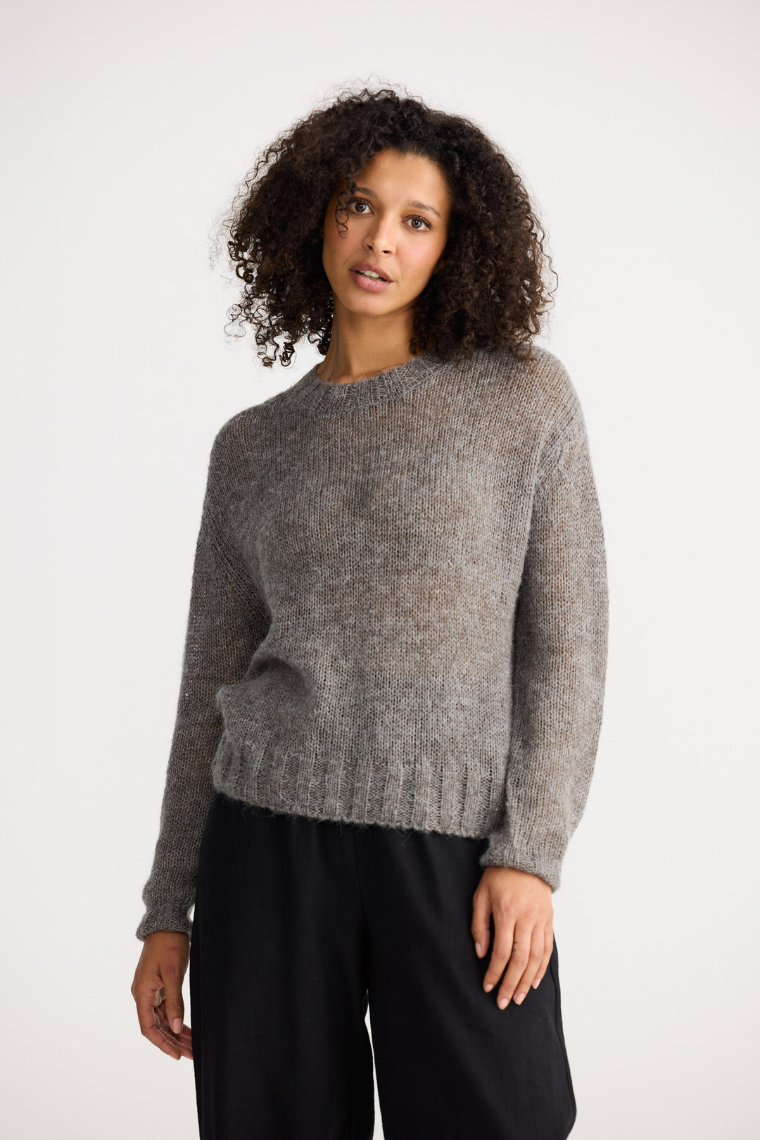 Model wearing charcoal Momento Knit, angled front view on white background