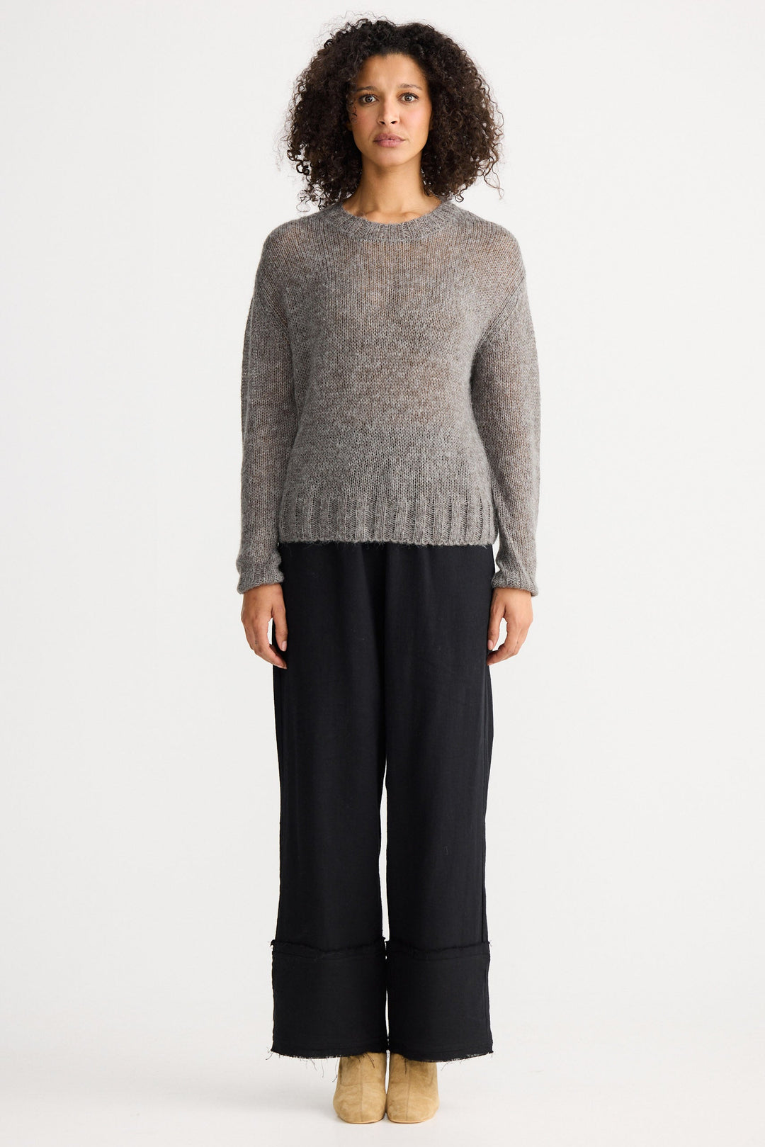 Model wearing charcoal Momento Knit, front view on white background