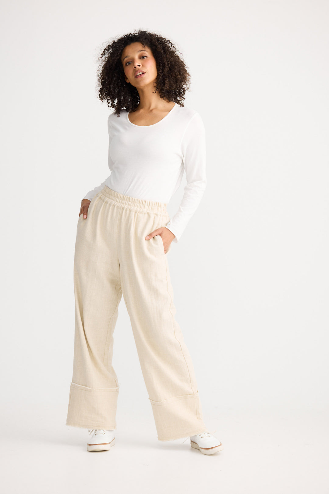 Model wearing natural Cadiz Pant, side view on white background