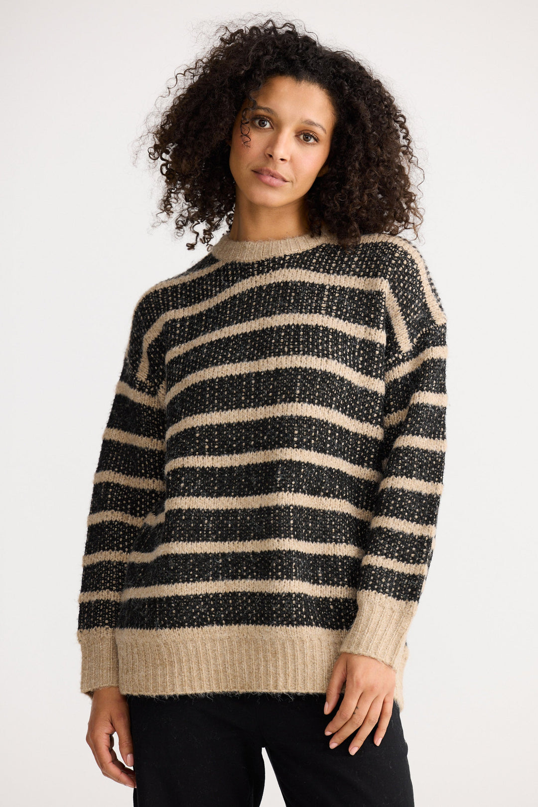 Model wearing black w cedar stripe Mira Knit, back view on white background