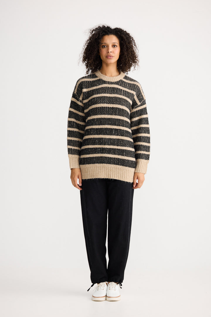 Model wearing black w cedar stripe Mira Knit, angled front view on white background