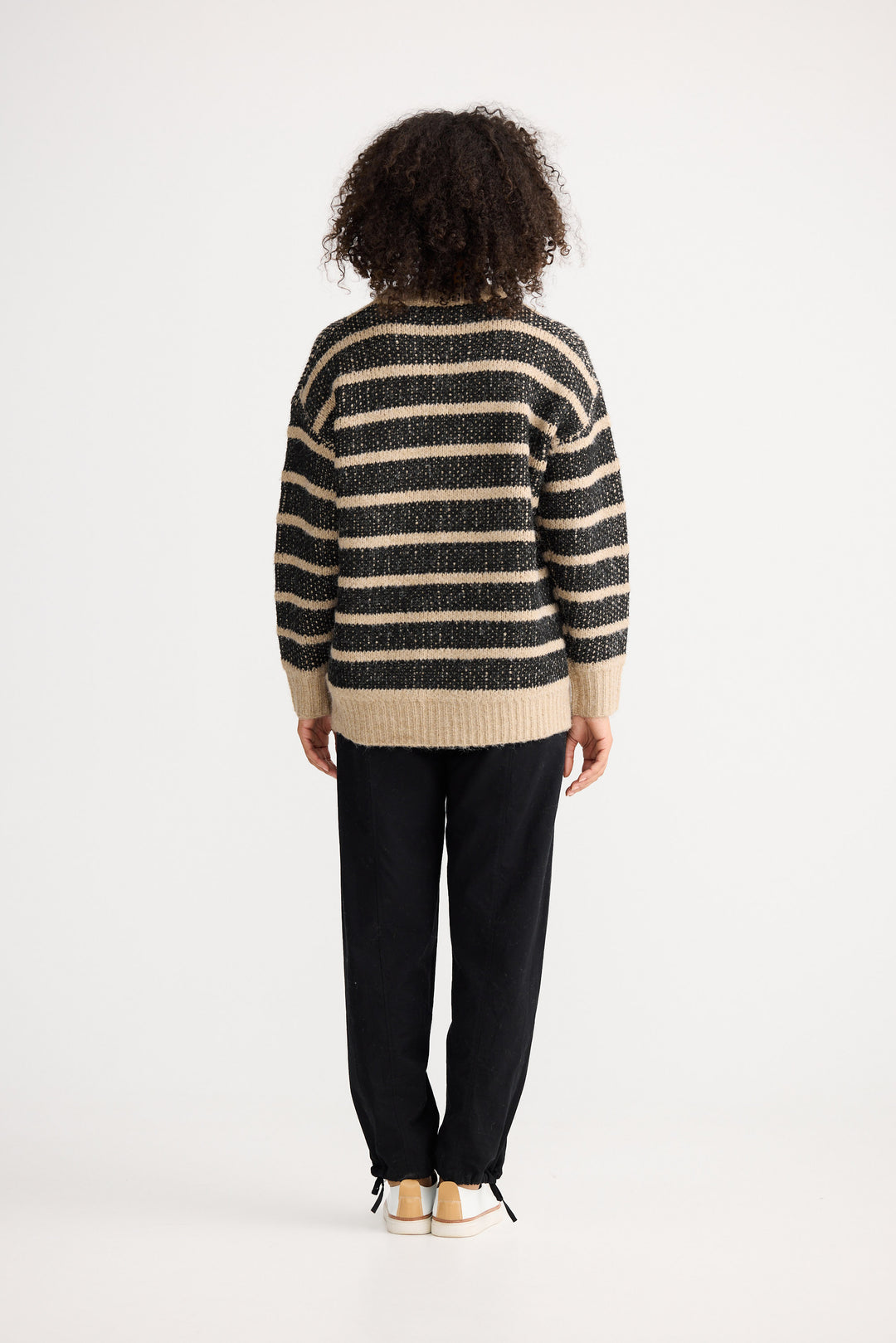 Model wearing black w cedar stripe Mira Knit, front view on white background