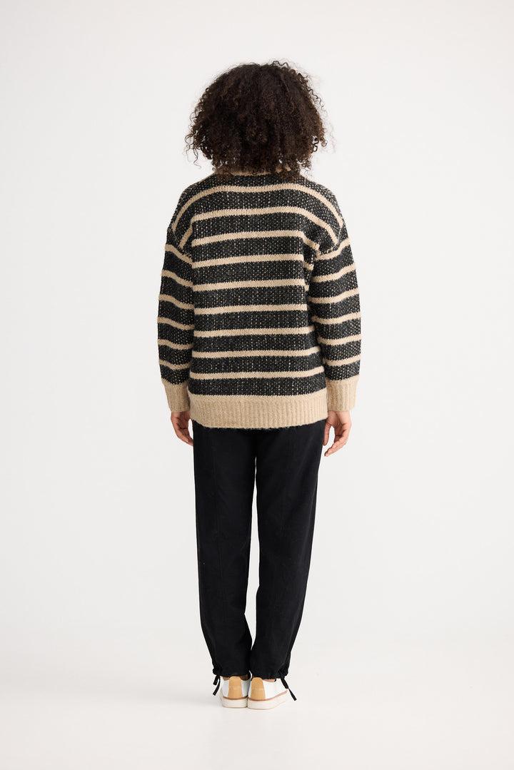 Model wearing black w cedar stripe Mira Knit, front view on white background