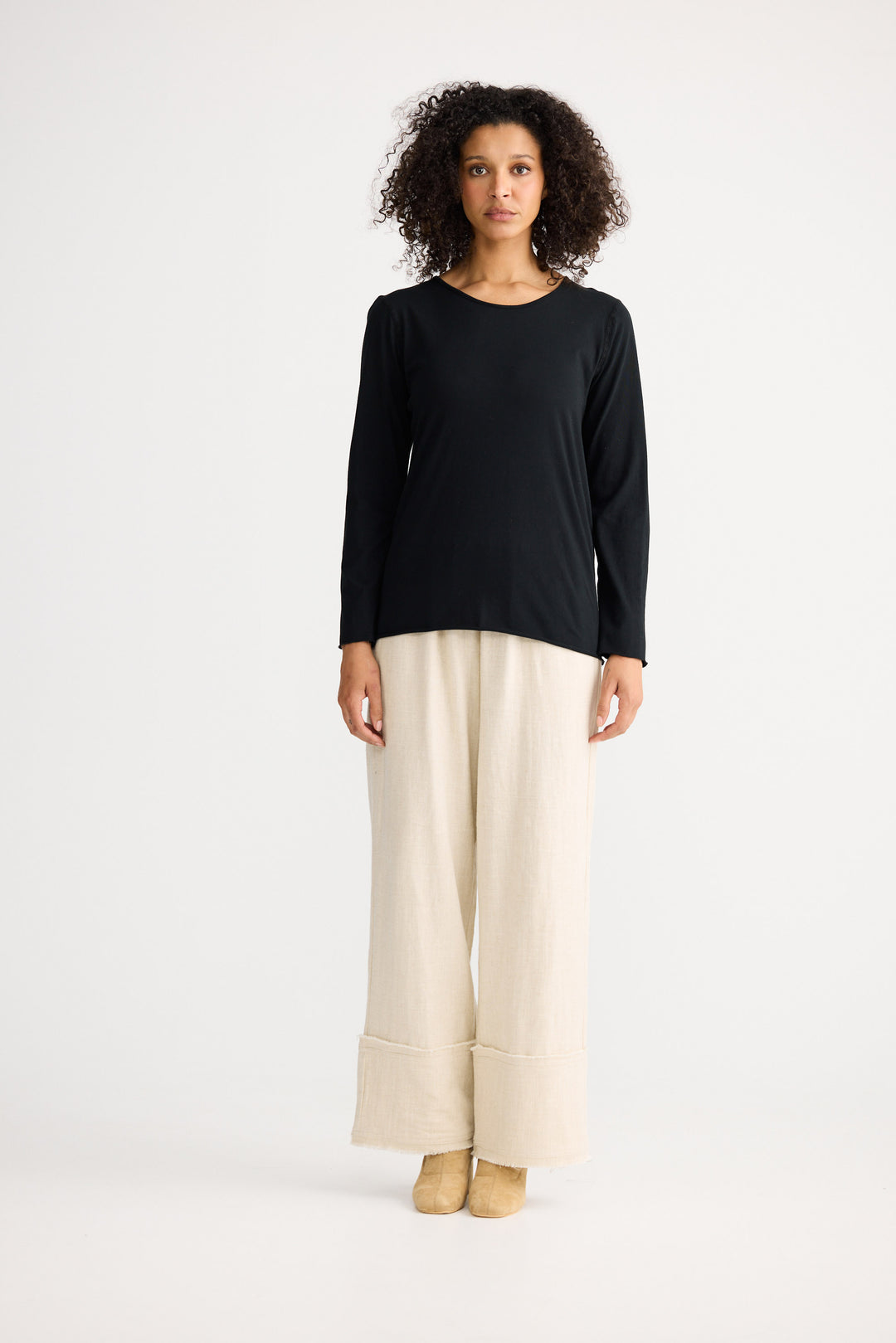 Model wearing black Kasai Long Sleeve Top, side view on white background