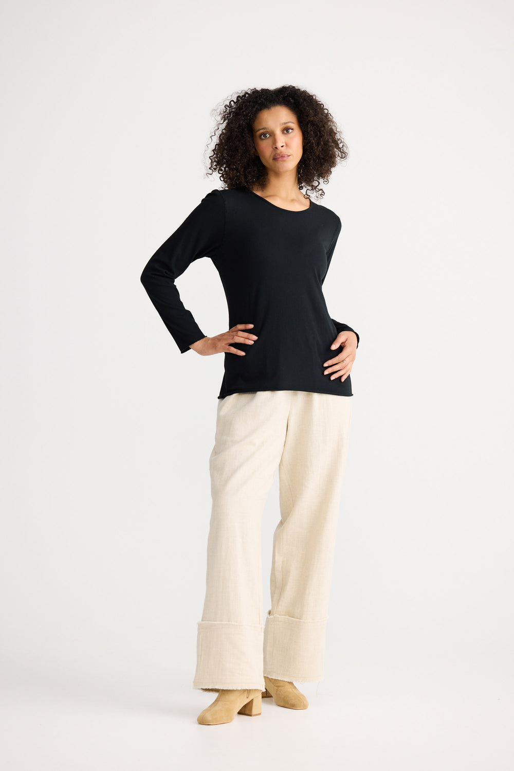 Model wearing black Kasai Long Sleeve Top, angled front view on white background