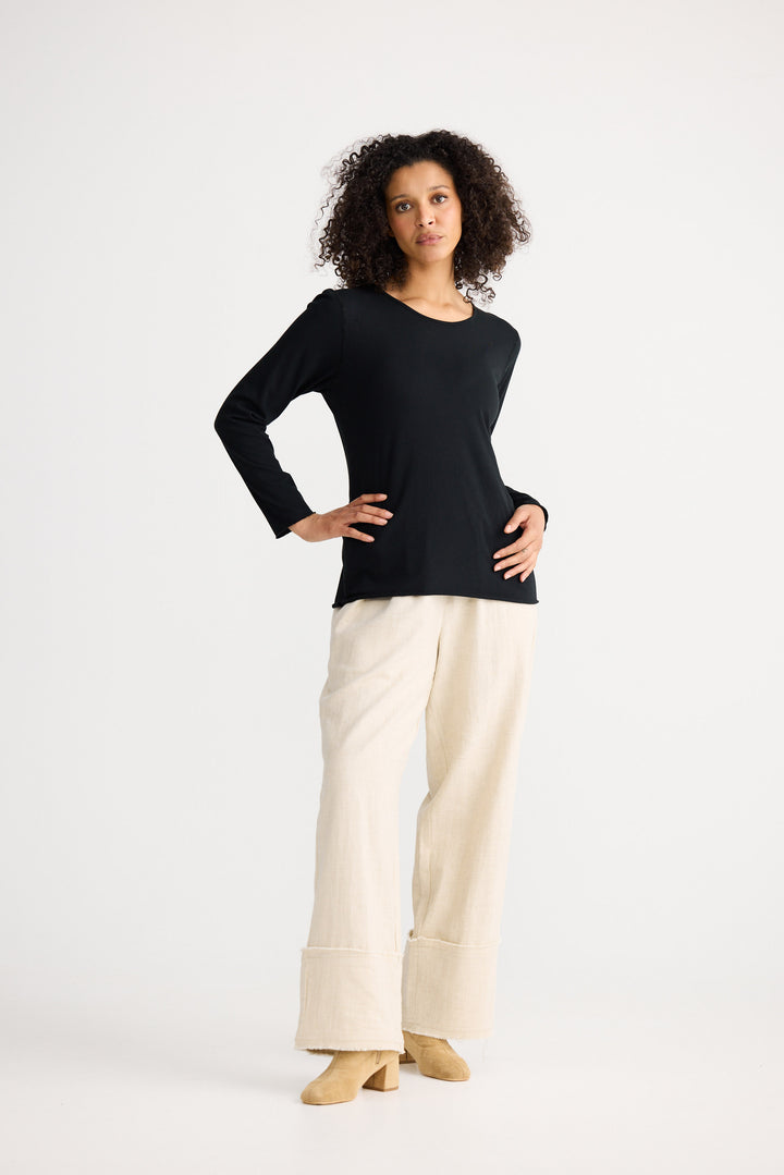 Model wearing black Kasai Long Sleeve Top, angled front view on white background