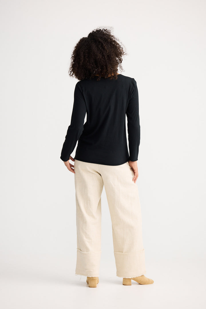 Model wearing black Kasai Long Sleeve Top, front view on white background