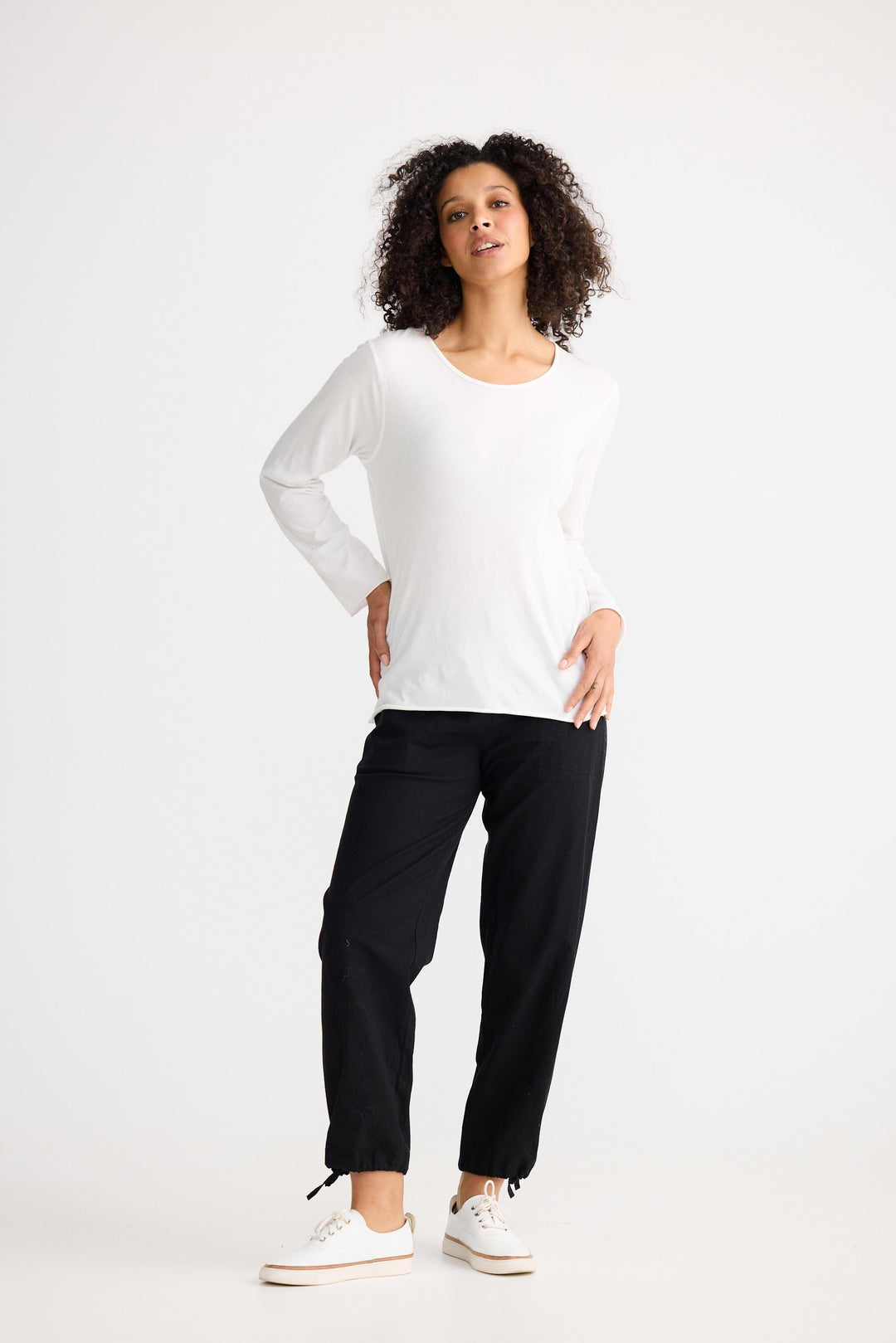 Model wearing ivory Kasai Long Sleeve Top, side view on white background