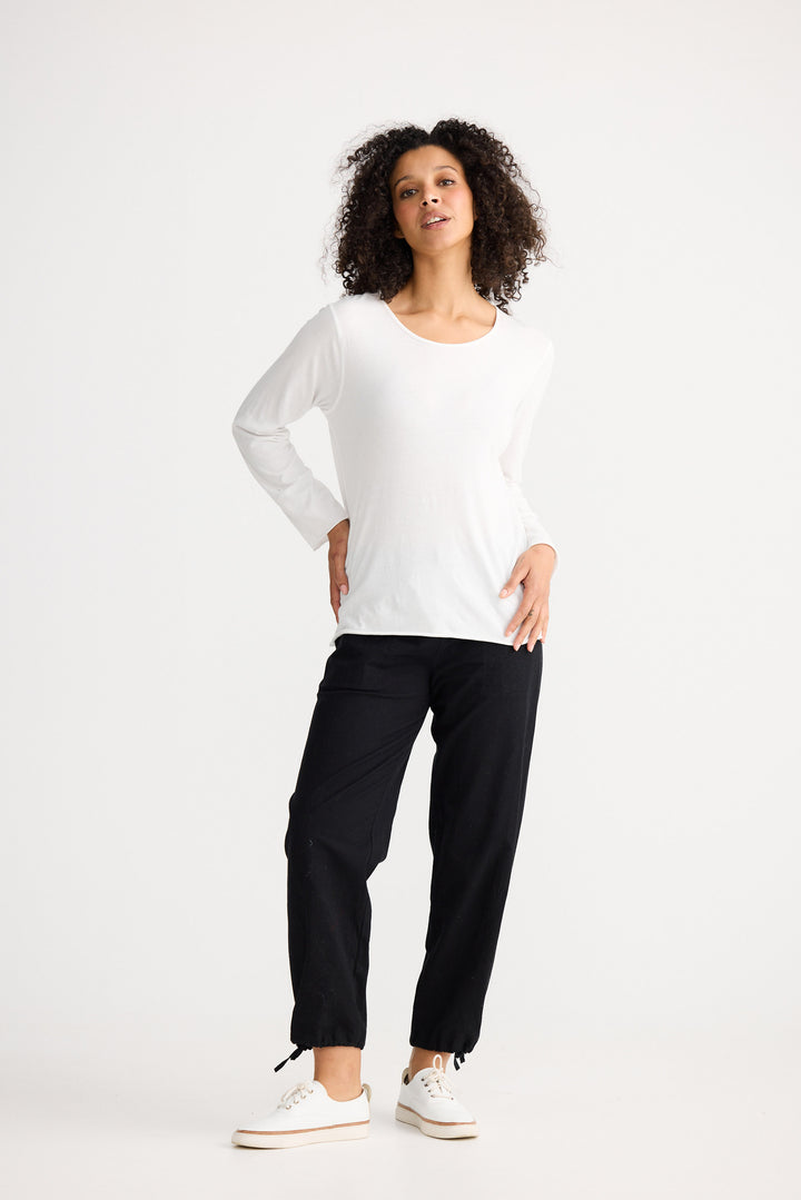 Model wearing ivory Kasai Long Sleeve Top, side view on white background