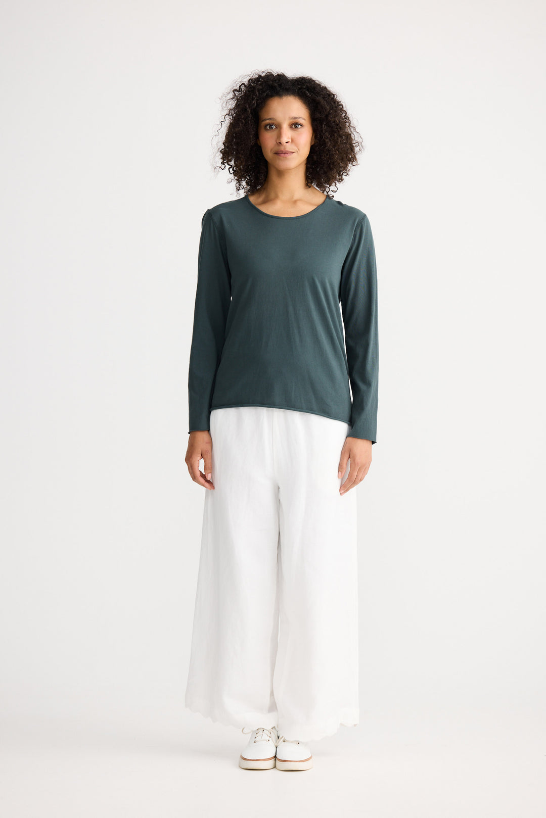 Model wearing slate Kasai Long Sleeve Top, back view on white background