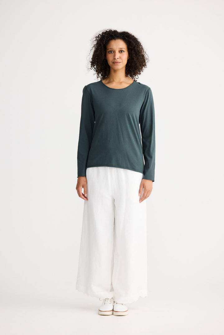 Model wearing slate Kasai Long Sleeve Top, back view on white background