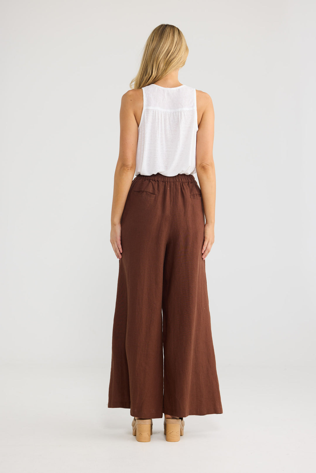 Model wearing Positano Pants in chocolate linen, front view.