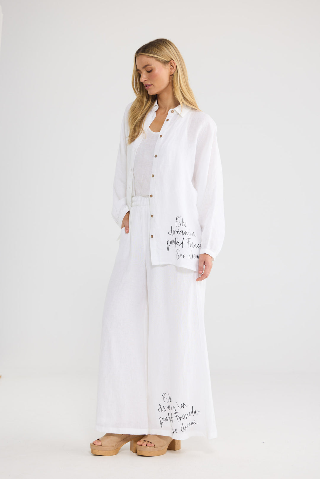Model wearing Positano Pants in white linen, front view.
