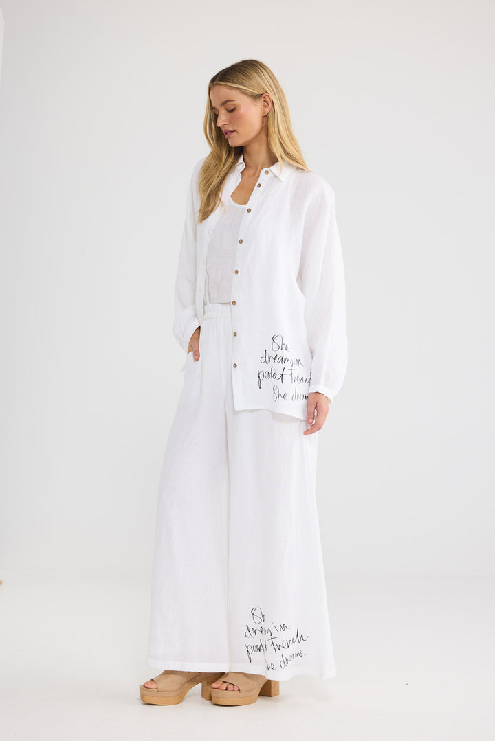 Model wearing Positano Pants in white linen, front view.