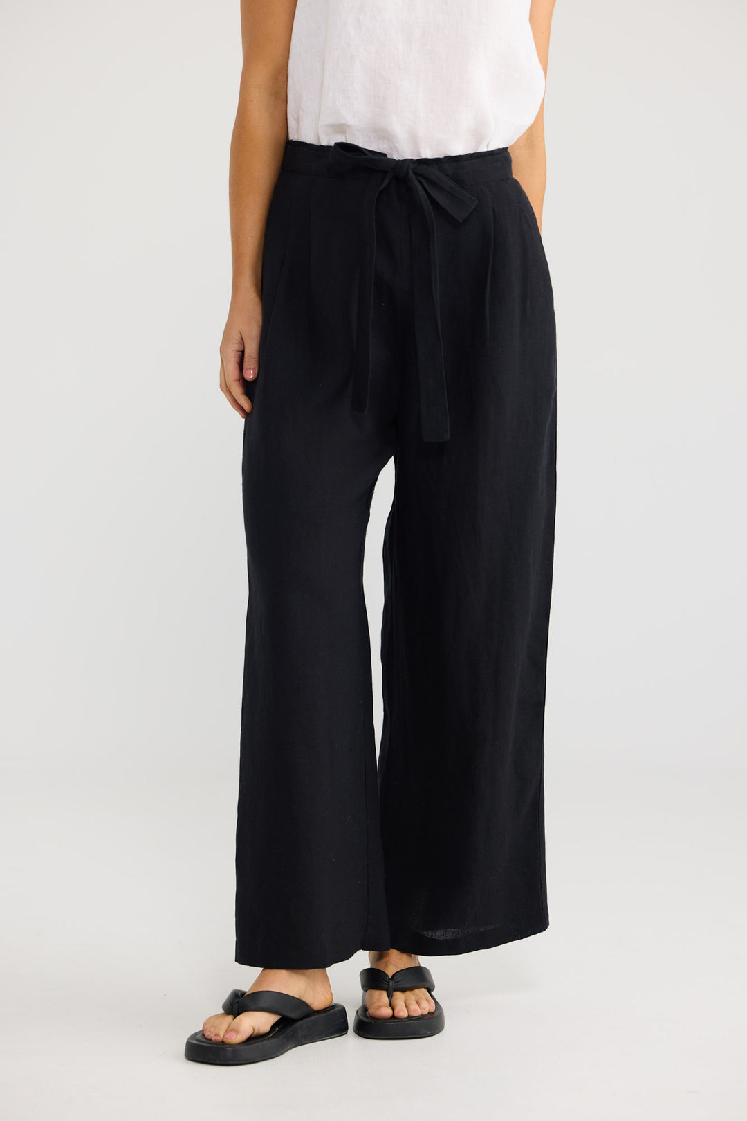 Model wearing Dickens Pant in black linen, front view.