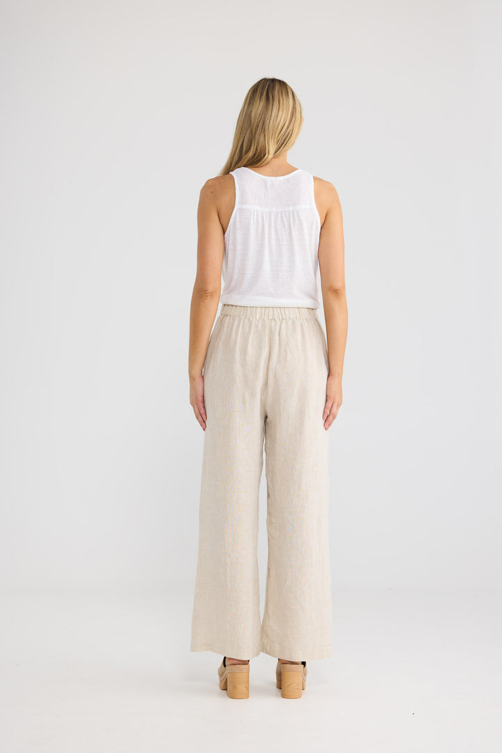 Model wearing Dickens Pant in natural linen, front view.