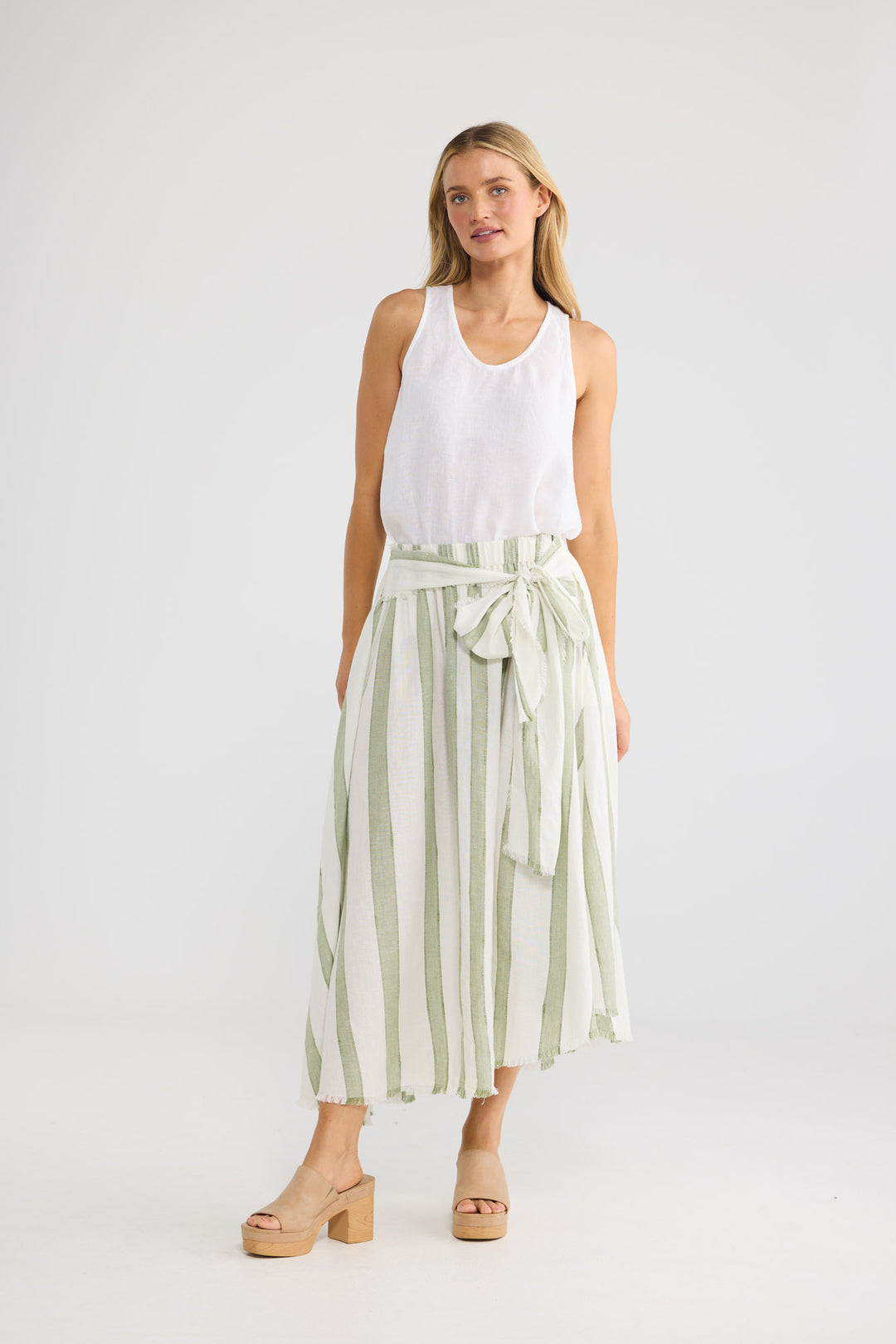 Model wearing The Edit Skirt in Sage Shadow Stripe, front view.