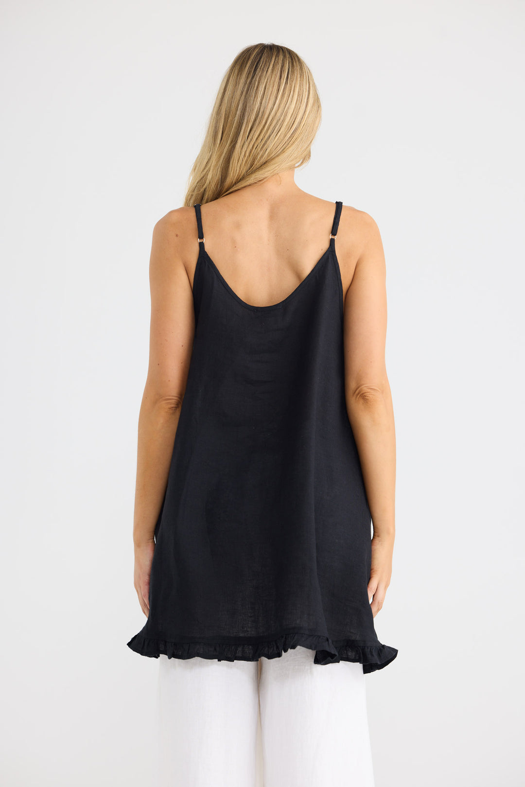 Model wearing Alina Singlet in black with a contrast cross patch, front view.